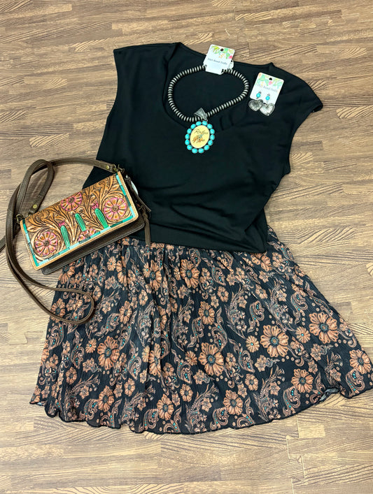 Miranda Skort with a modest, flowy silhouette and built-in shorts, featuring a classic tooled leather print. Styled for comfort and movement, it blends feminine flair with a touch of western grit.