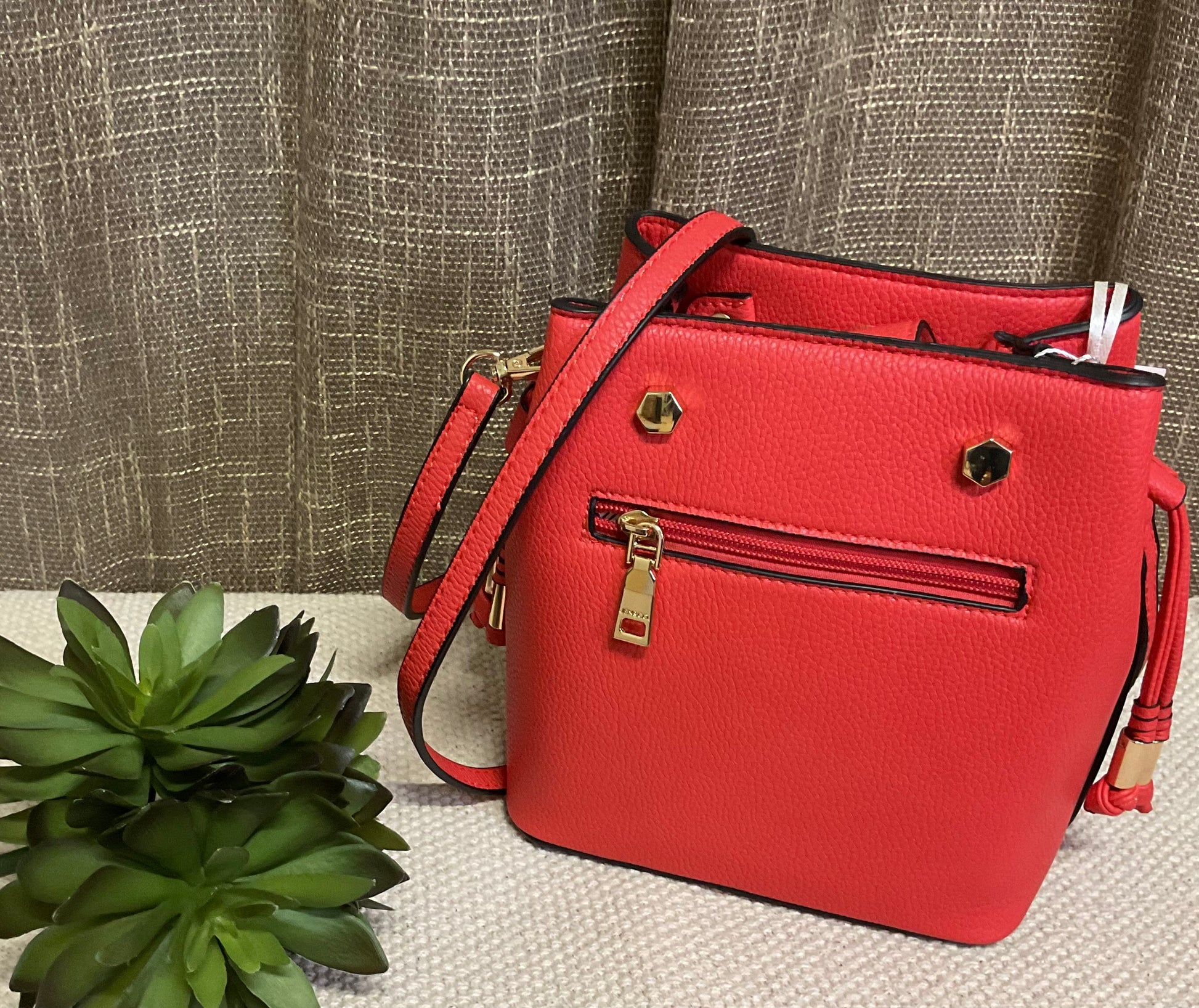 Marion Bucket Bag in high-quality vegan leather with adjustable strap, gold-toned hardware, and side drawstring – available in rich brown lizard print or bold red for versatile, stylish everyday use.