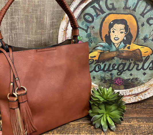 Tomball Leopard Contrast Bag in warm brown vegan leather with bold leopard-print sides, braided handle, and removable tassels – versatile, stylish handbag for day-to-night wear.