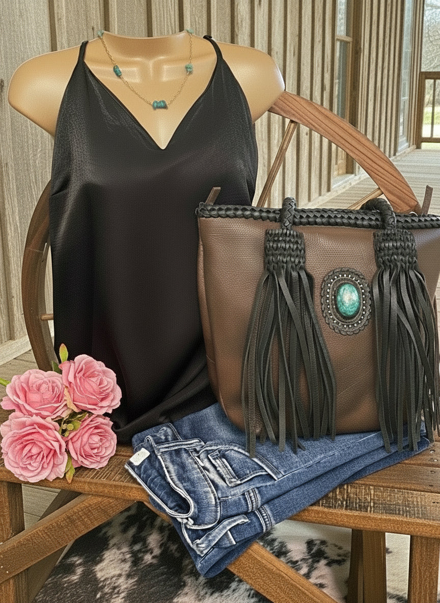 American Darling full-grain leather tote with leather fringe and a turquoise stone accent on the front. Approximately 11" (H) x 14" (W) x 5" (D).