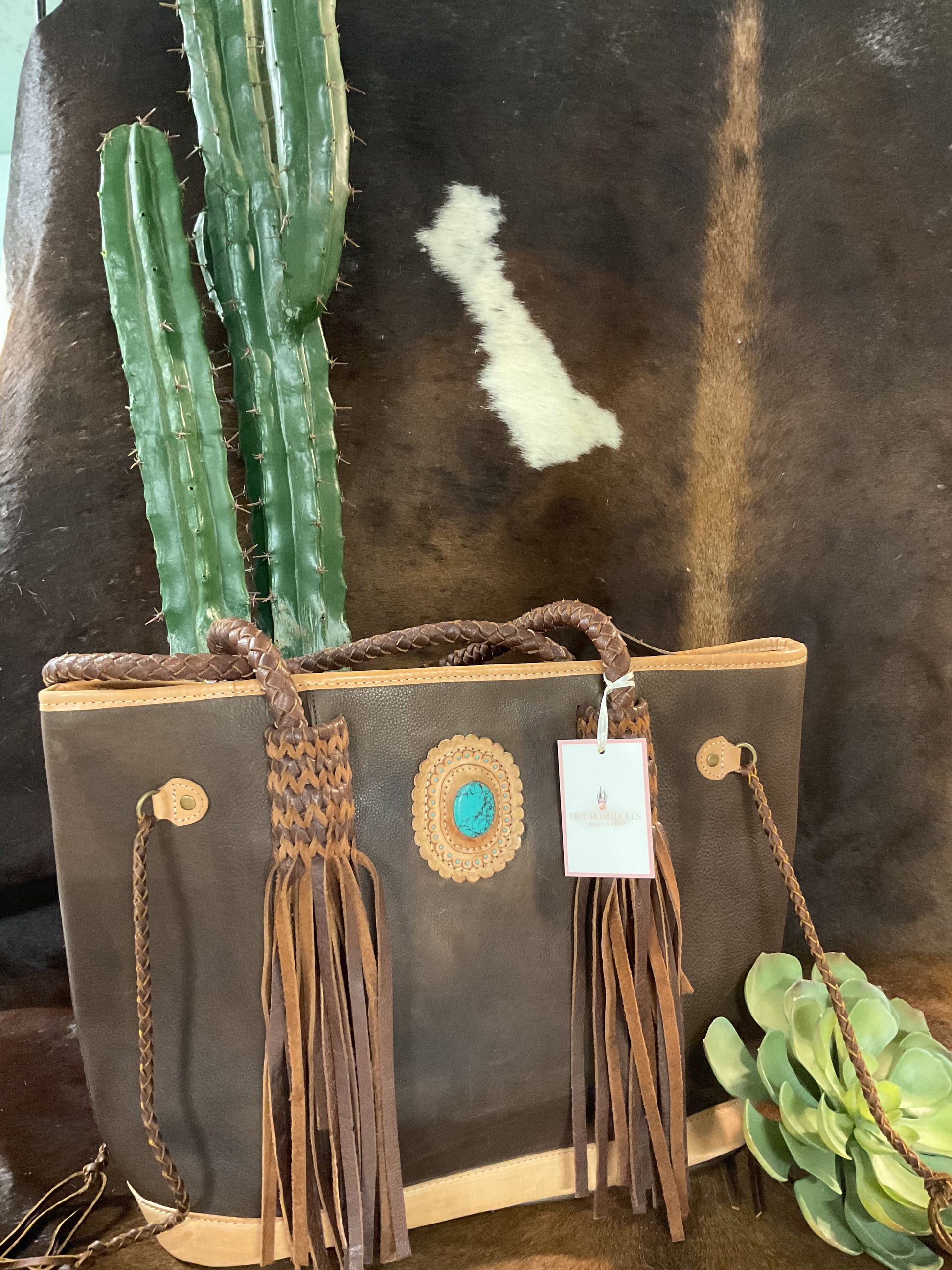 American Darling Gonzales Tote crafted from quality leather, featuring fringe detailing and a bold turquoise stone accent for a stylish western look.