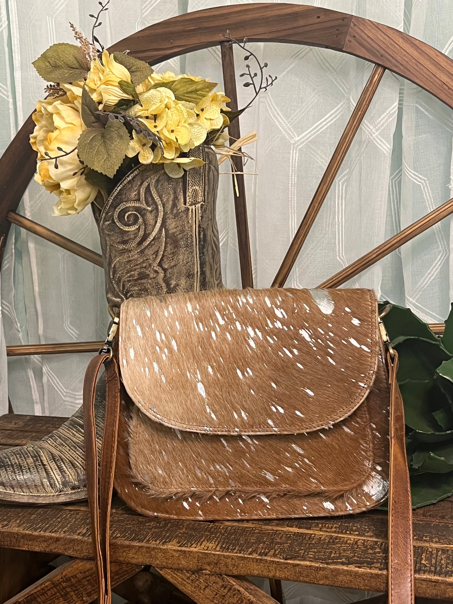 Falls City Bag by Crazy Heifers – handmade leather and cowhide bag with silver splatter design, adjustable strap, zippered front pocket, and magnetic snap closure.