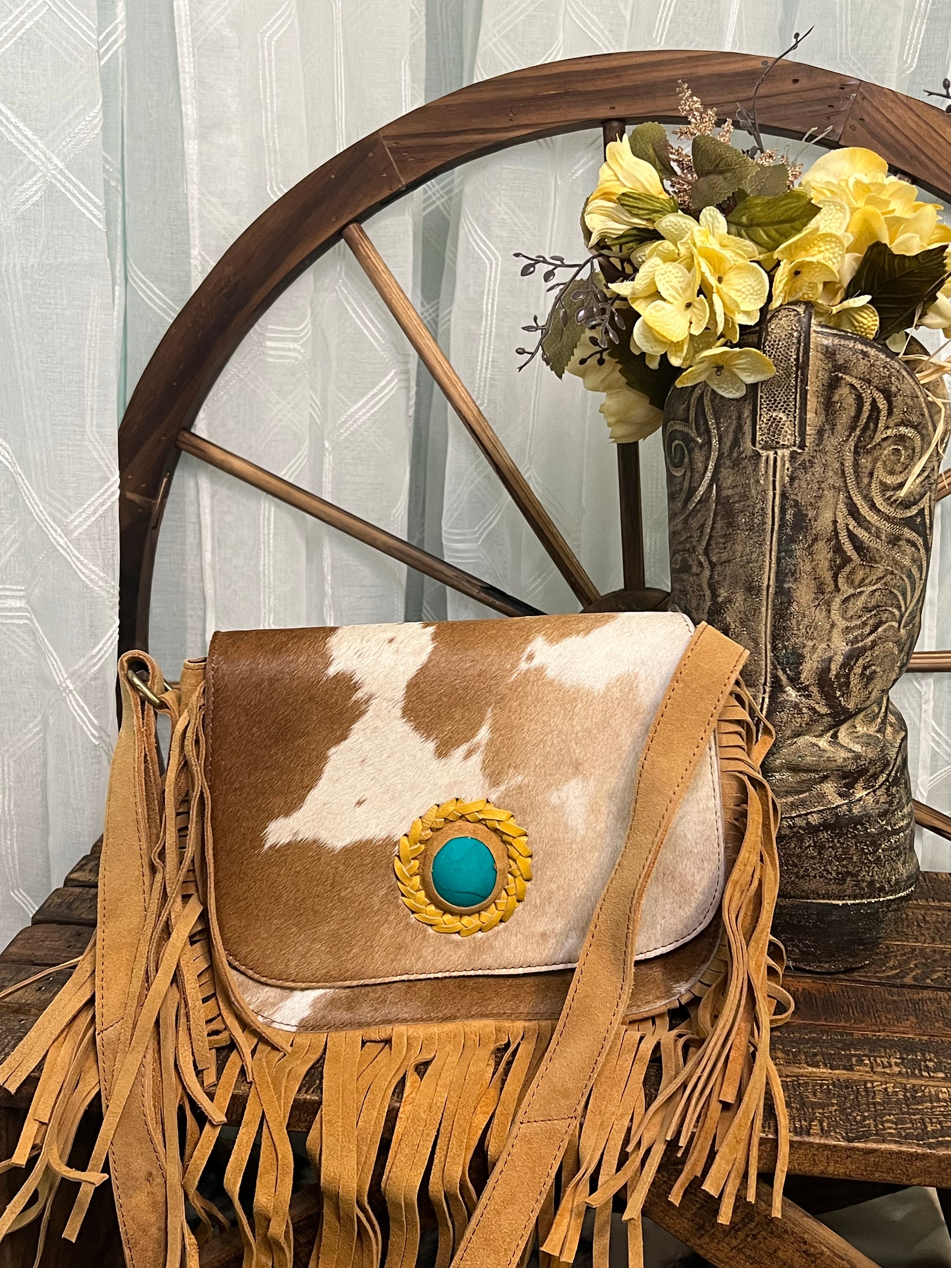 San Benito Bag – genuine rough leather and hair-on-cowhide bag with fringe, turquoise stone accent, zippered pockets, and magnetic snap flap closure for western style.