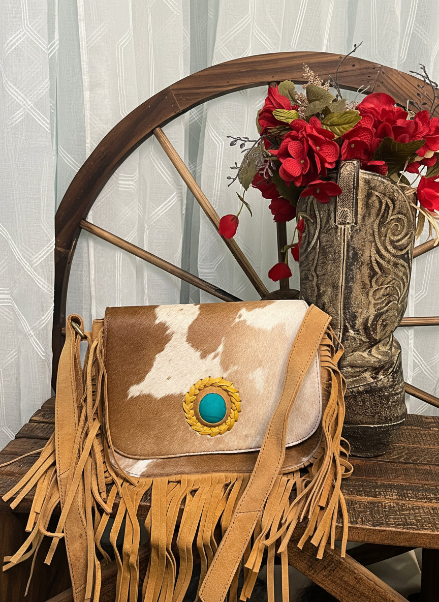 San Benito Bag – genuine rough leather and hair-on-cowhide bag with fringe, turquoise stone accent, zippered pockets, and magnetic snap flap closure for western style.