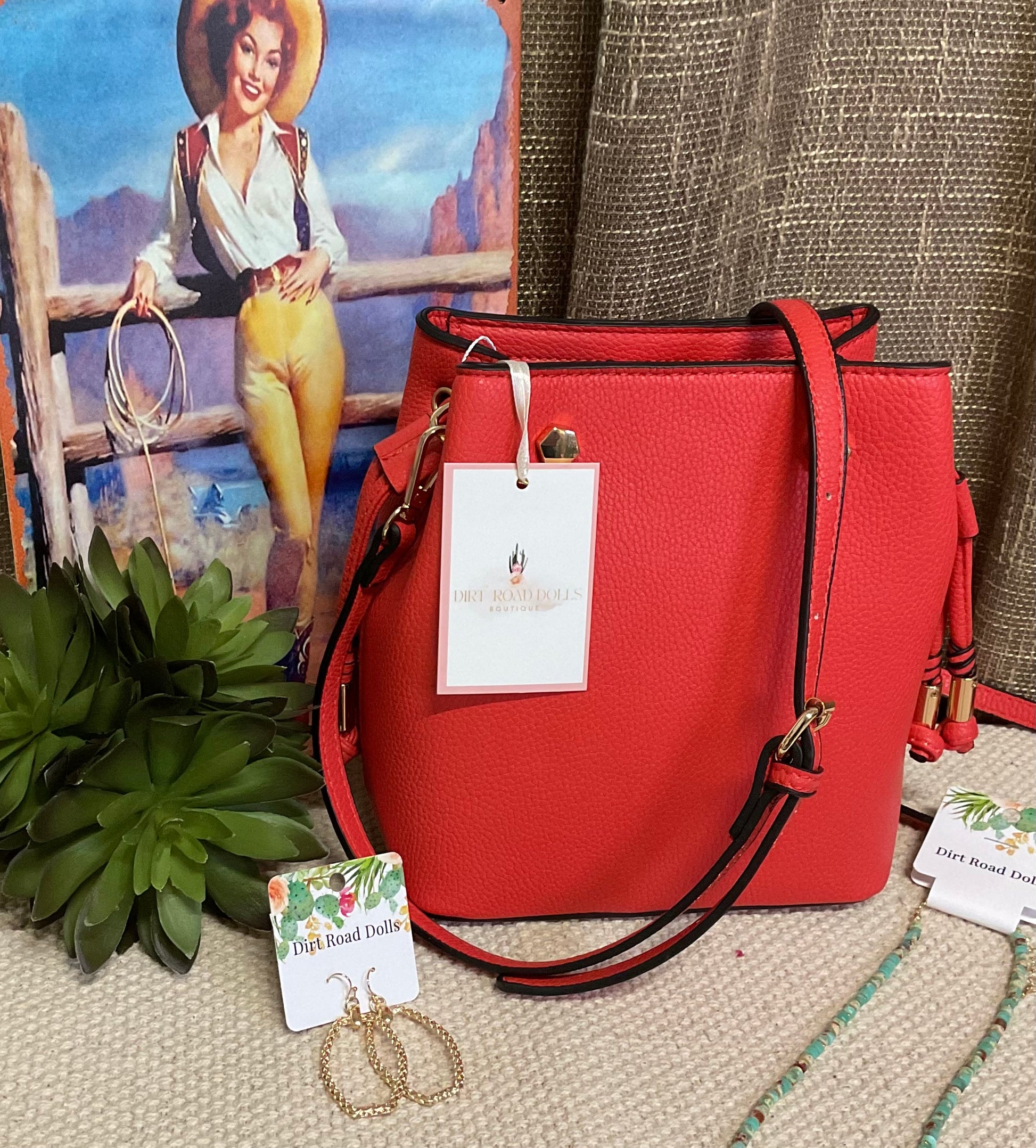 Marion Bucket Bag in high-quality vegan leather with adjustable strap, gold-toned hardware, and side drawstring – available in rich brown lizard print or bold red for versatile, stylish everyday use.