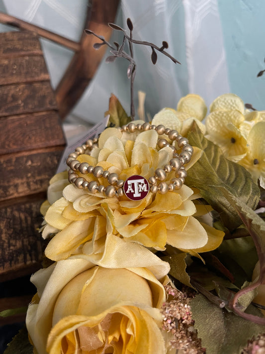 double strand gold plated beaded stretch bracelet with maroon and white Texas A&M University enamel logo