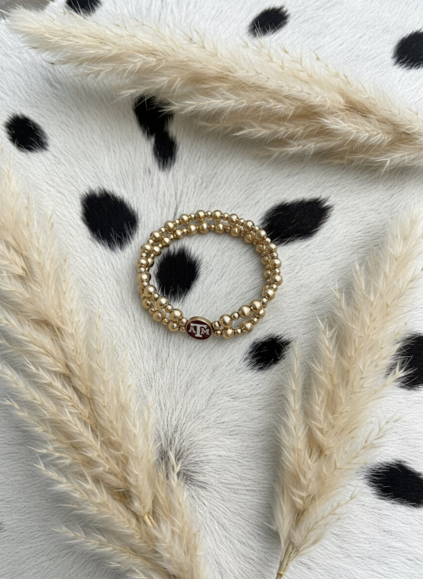 double strand gold plated beaded stretch bracelet with maroon and white Texas A&M University enamel logo