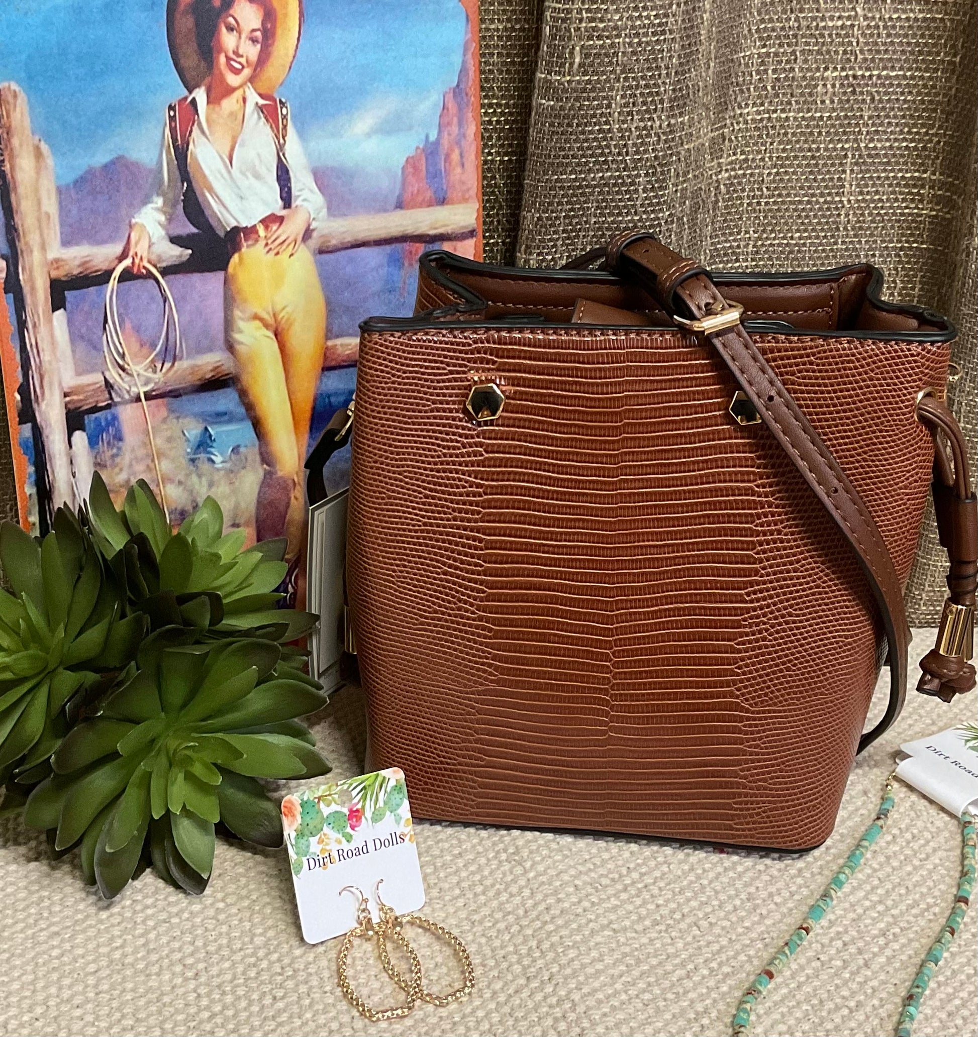 Marion Bucket Bag in high-quality vegan leather with adjustable strap, gold-toned hardware, and side drawstring – available in rich brown lizard print or bold red for versatile, stylish everyday use.