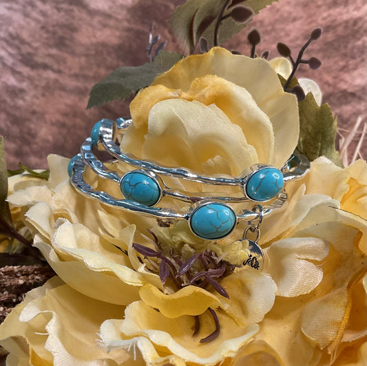 set of three burnished silver toned bangle bracelets with faux turquoise stones
