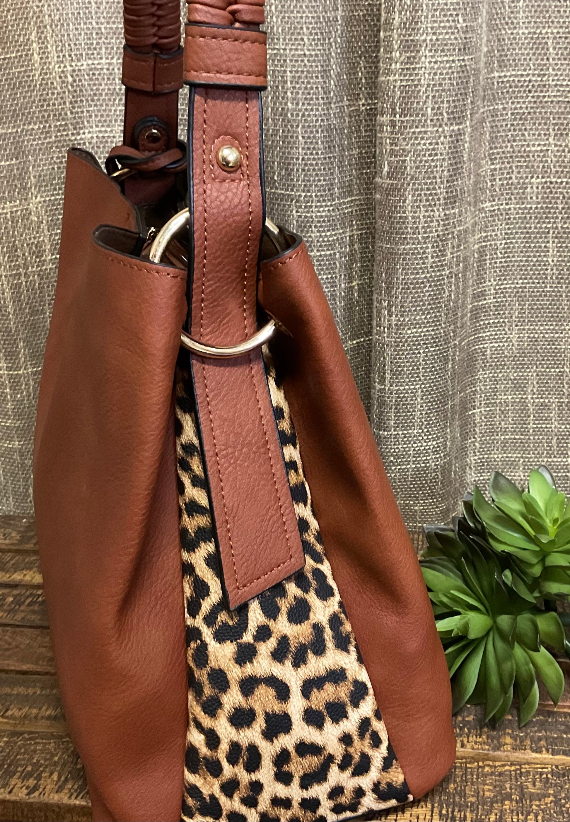 Tomball Leopard Contrast Bag in warm brown vegan leather with bold leopard-print sides, braided handle, and removable tassels – versatile, stylish handbag for day-to-night wear.