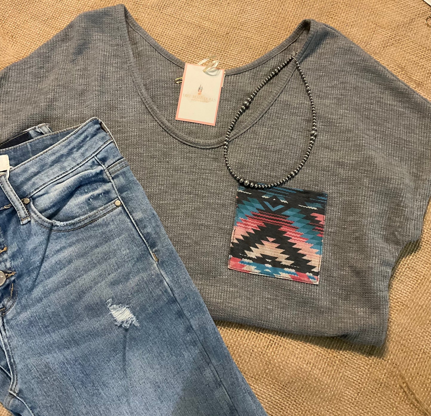 Sasha Top in a cozy waffle knit fabric with a short sleeve silhouette, scoop neckline, and rounded hem. Features an Aztec-inspired chest pocket for a pop of southwestern style. Available in ivory or heather grey.