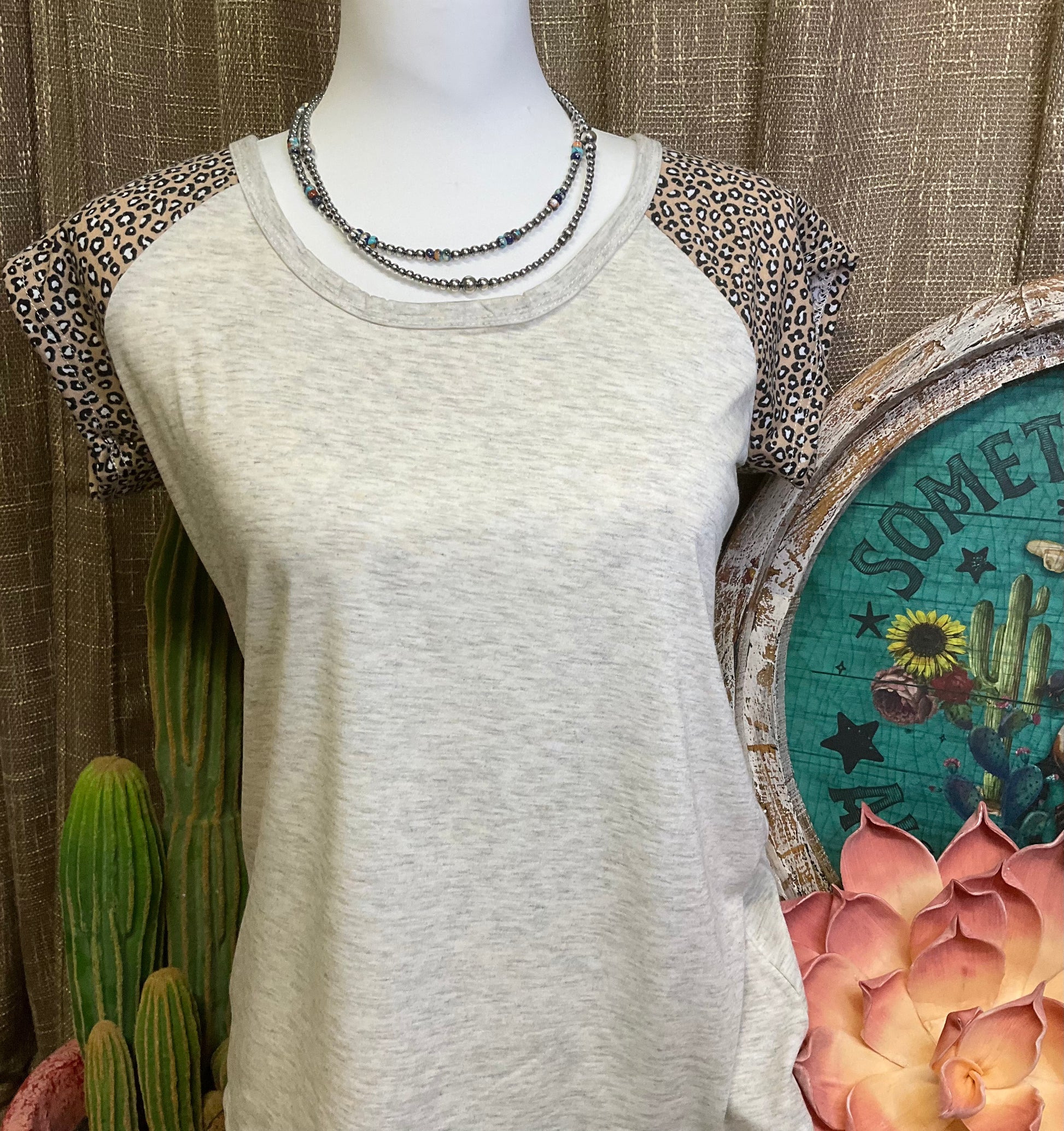 Gloria Leopard Sleeve Top featuring buttery soft fabric with bold leopard print sleeves, offering a chic and comfortable statement piece for any outfit.