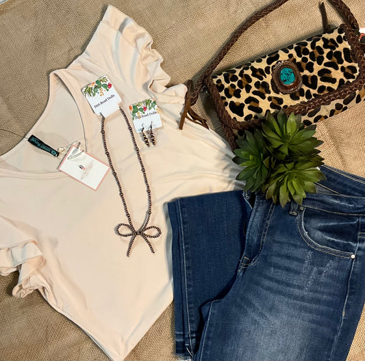 Image of the cream-colored Elaine Ruffle Top featuring a flattering V-neckline and delicate ruffle sleeves, crafted from luxuriously soft fabric for an effortlessly elegant look