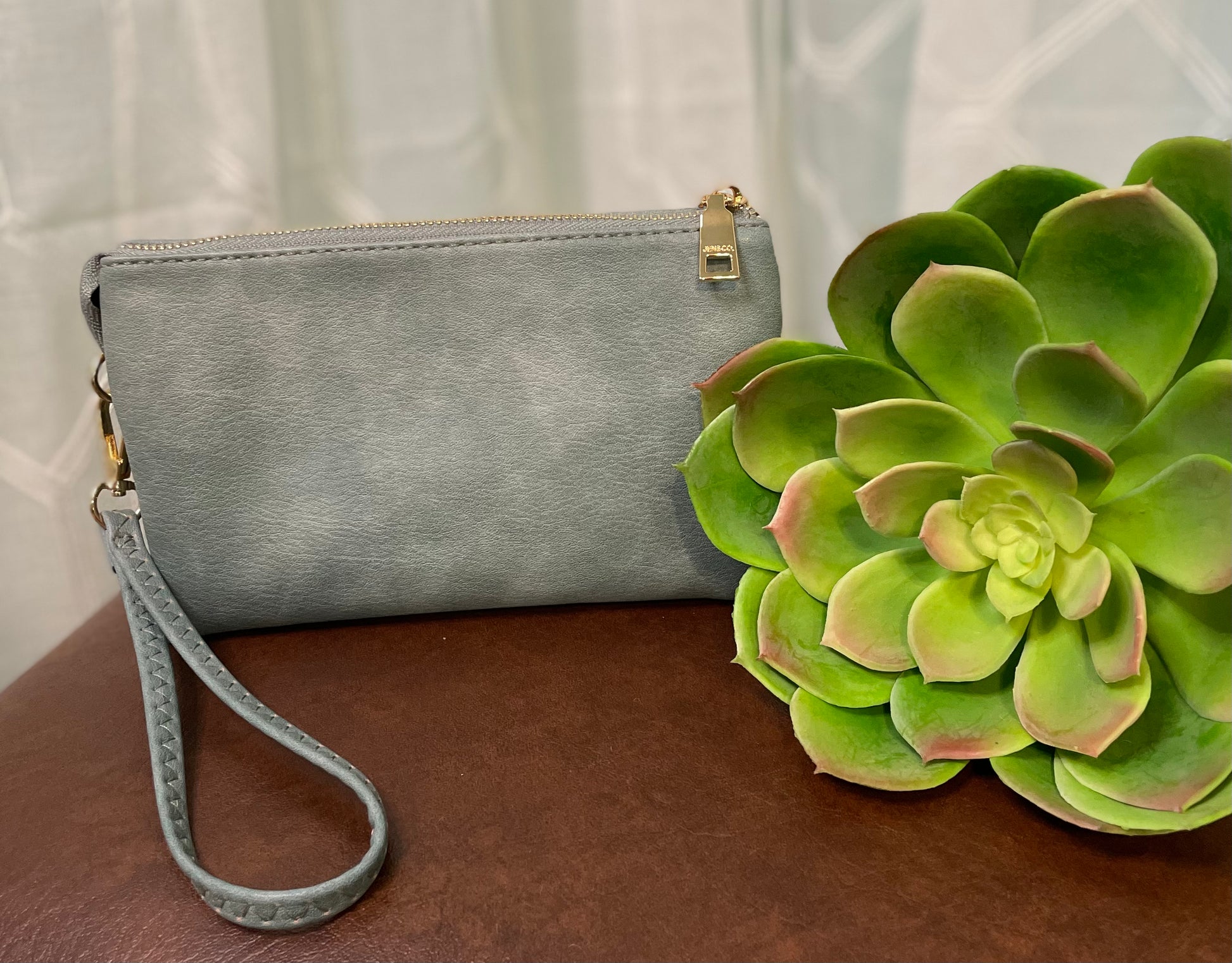 Poteet Crossbody bag with three compartments and built-in card holders, offering versatile crossbody and wristlet carrying options for stylish convenience.