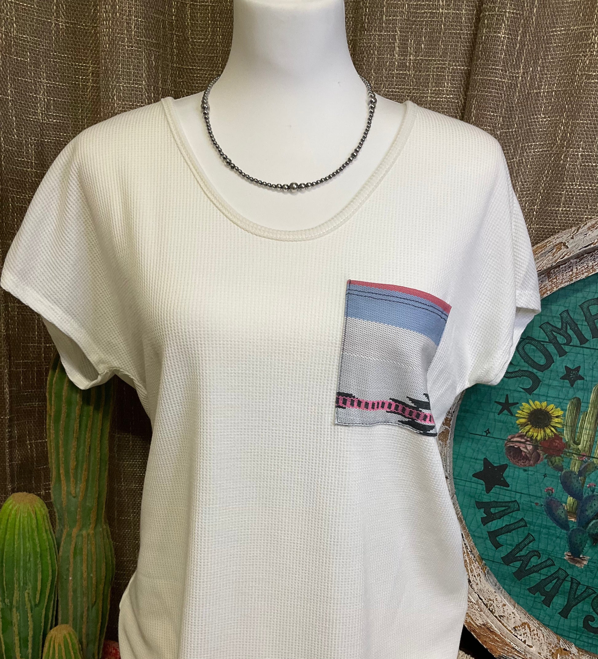 Sasha Top in a cozy waffle knit fabric with a short sleeve silhouette, scoop neckline, and rounded hem. Features an Aztec-inspired chest pocket for a pop of southwestern style. Available in ivory or heather grey.