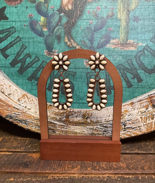 Wildflower Earrings featuring copper-toned concho-style dangles with white stone accents. Lightweight design with a 2.5-inch length and post back closure, blending earthy elegance with bold western charm.