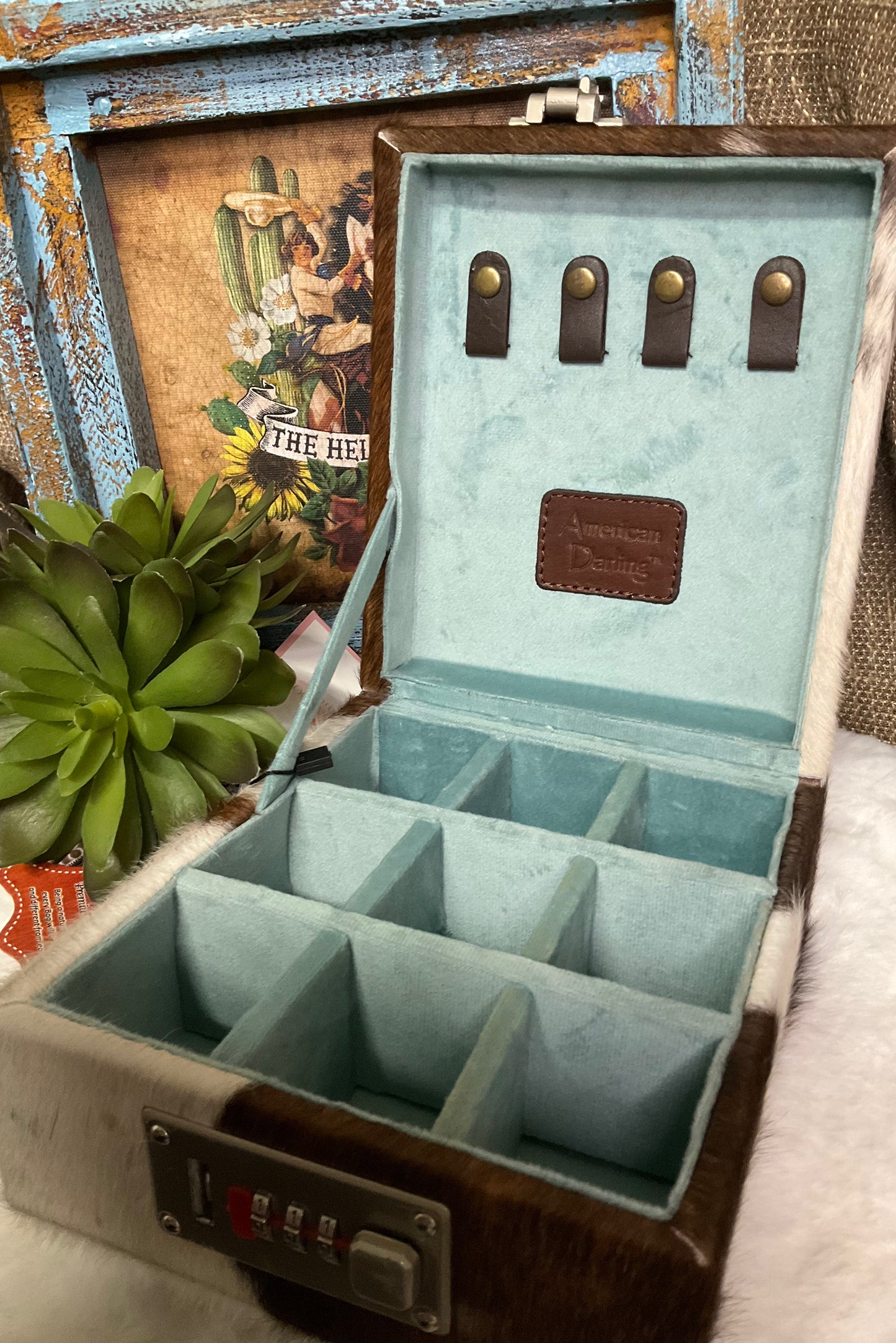 Hand-tooled leather and hair-on cowhide El Paso Jewelry Case by American Darling with 15 sections, snap closure straps, and a secure locking feature.