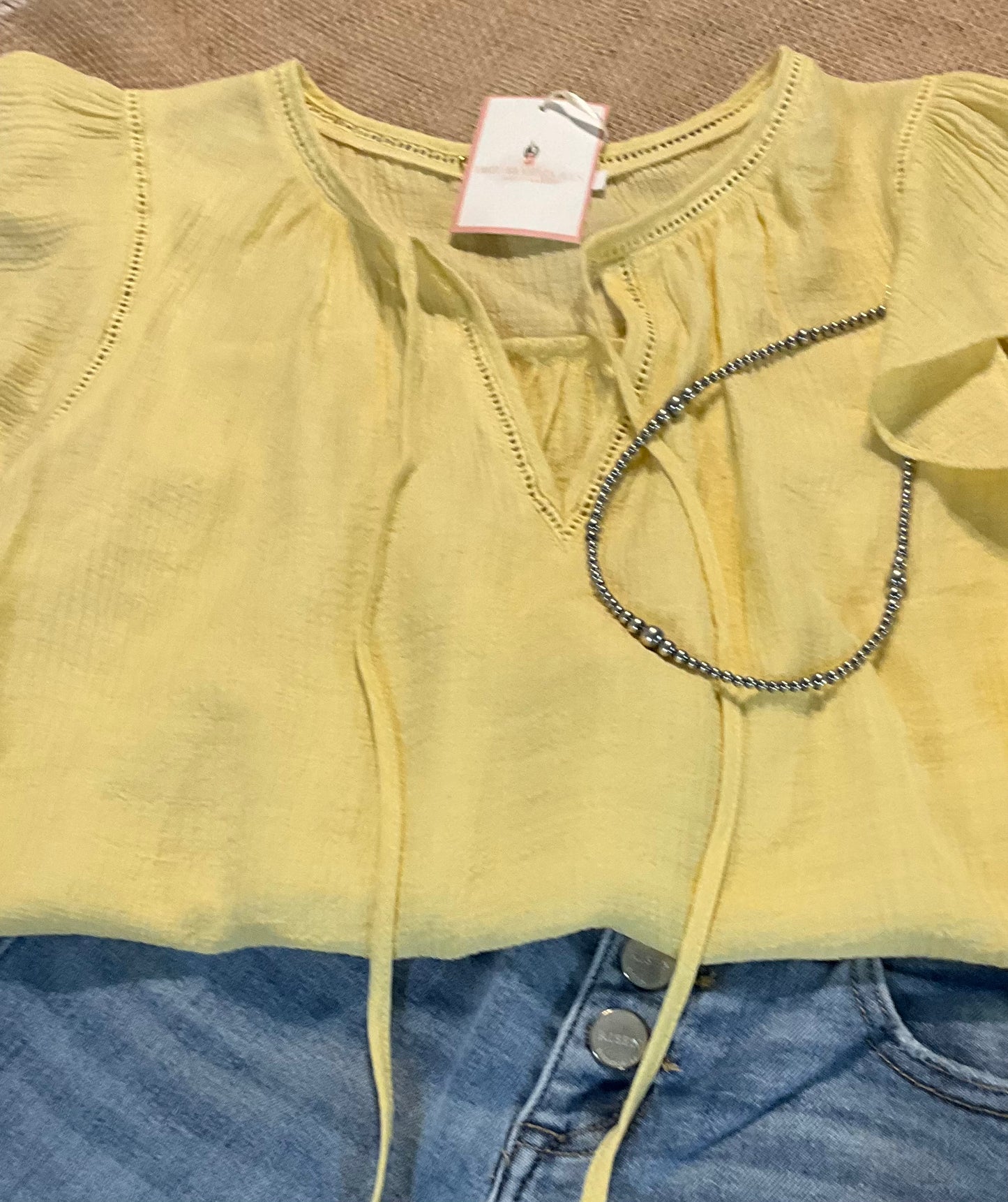 Leslie Ruffle Sleeve Top featuring feminine ruffle sleeves, offering a perfect blend of comfort and style.