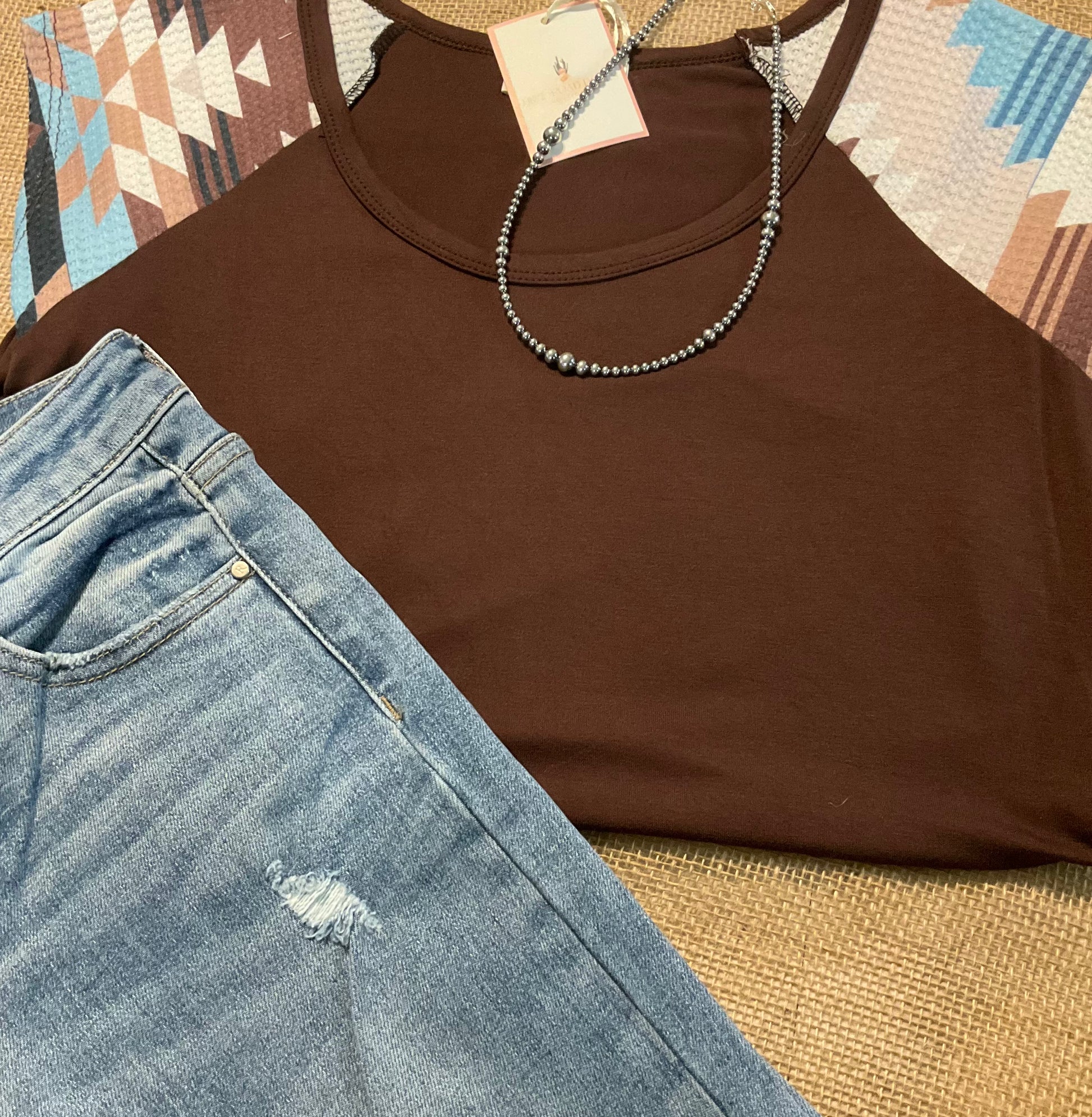 Carmen Aztec Sleeve Top featuring a soft, solid body with vibrant Aztec-patterned sleeves, adding a bold and colorful touch to your look.