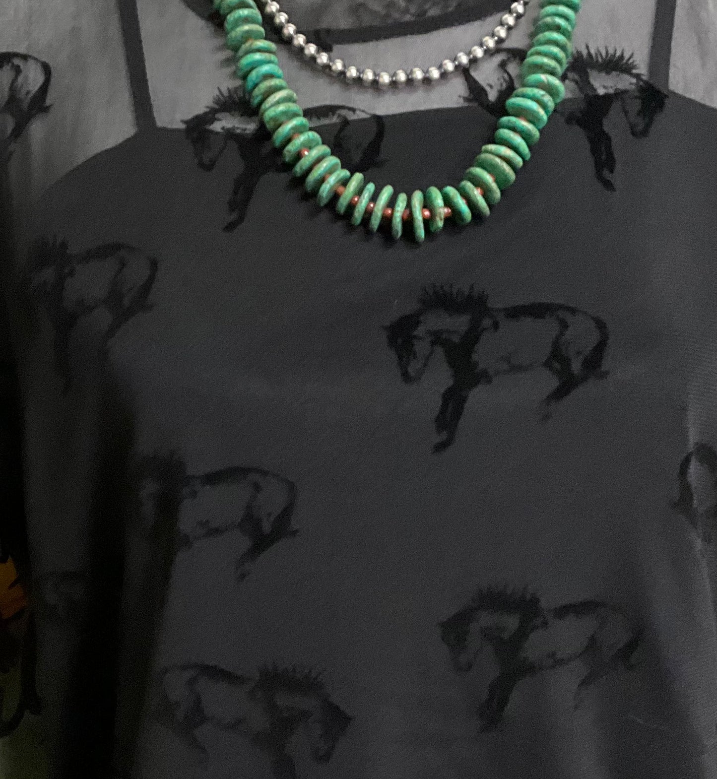 Close-up image of the Buck Off Mesh Tee showcasing a bold bucking horse pattern on a short-sleeve, stretchy fabric design, paired with an included cami for a complete, edgy look.