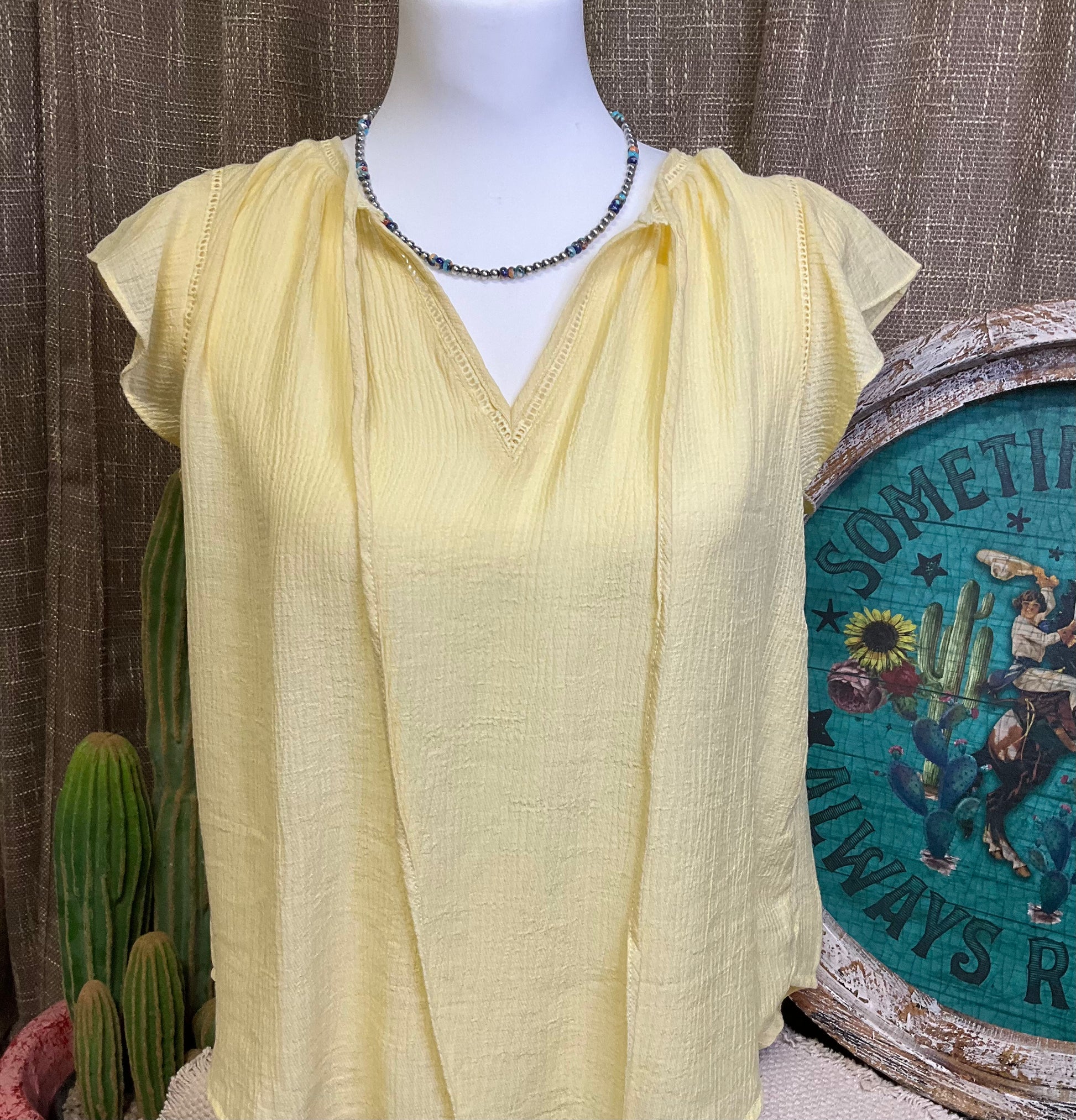 Leslie Ruffle Sleeve Top featuring feminine ruffle sleeves, offering a perfect blend of comfort and style.