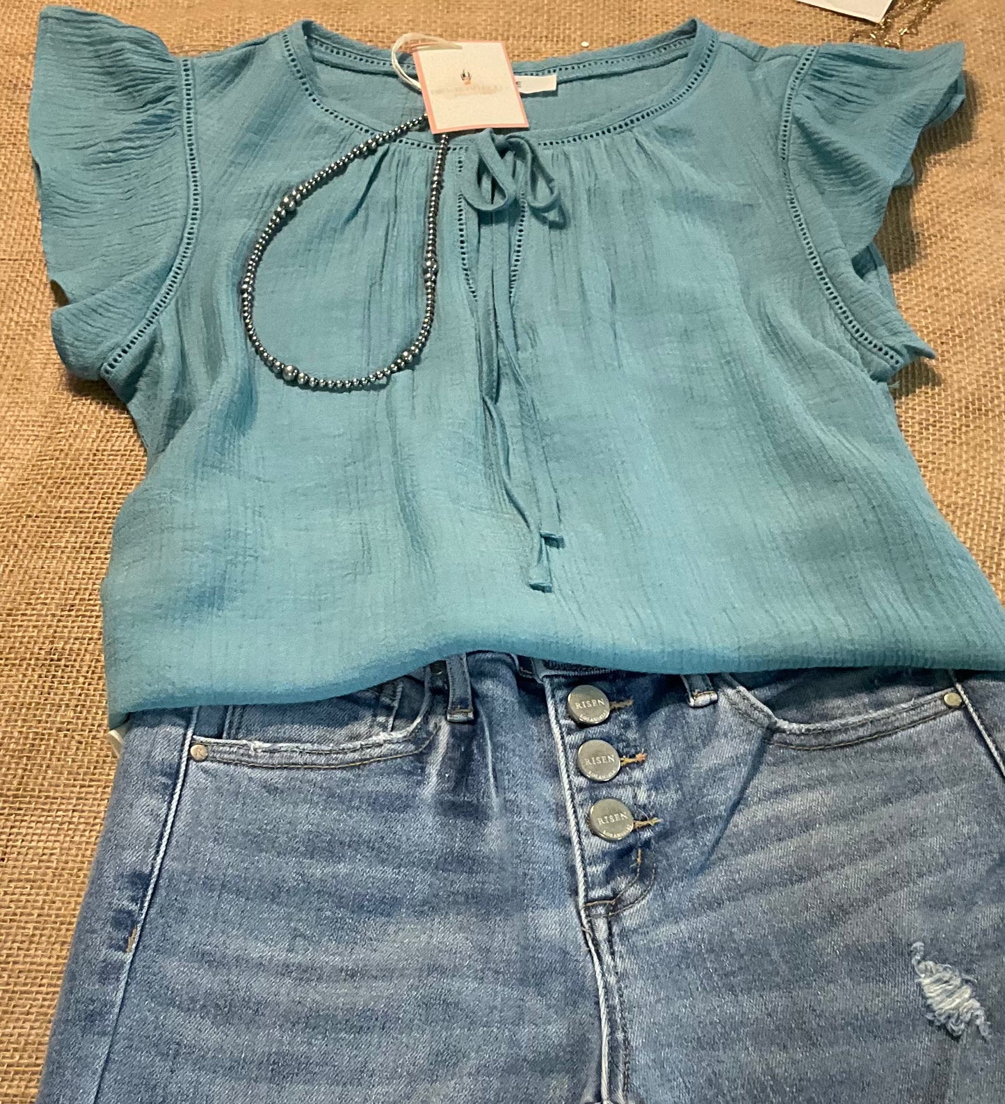 Leslie Ruffle Sleeve Top featuring feminine ruffle sleeves, offering a perfect blend of comfort and style.