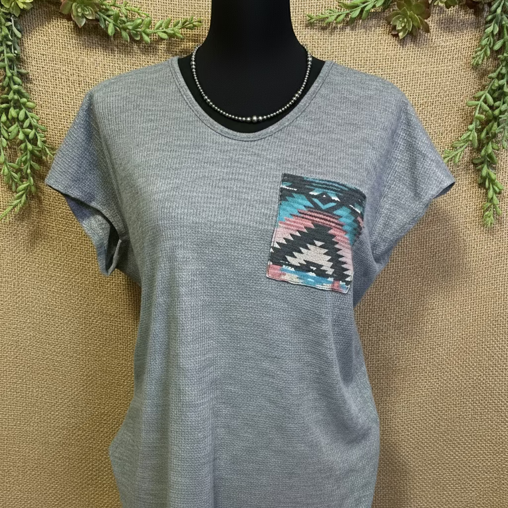 Sasha Top in a cozy waffle knit fabric with a short sleeve silhouette, scoop neckline, and rounded hem. Features an Aztec-inspired chest pocket for a pop of southwestern style. Available in ivory or heather grey.