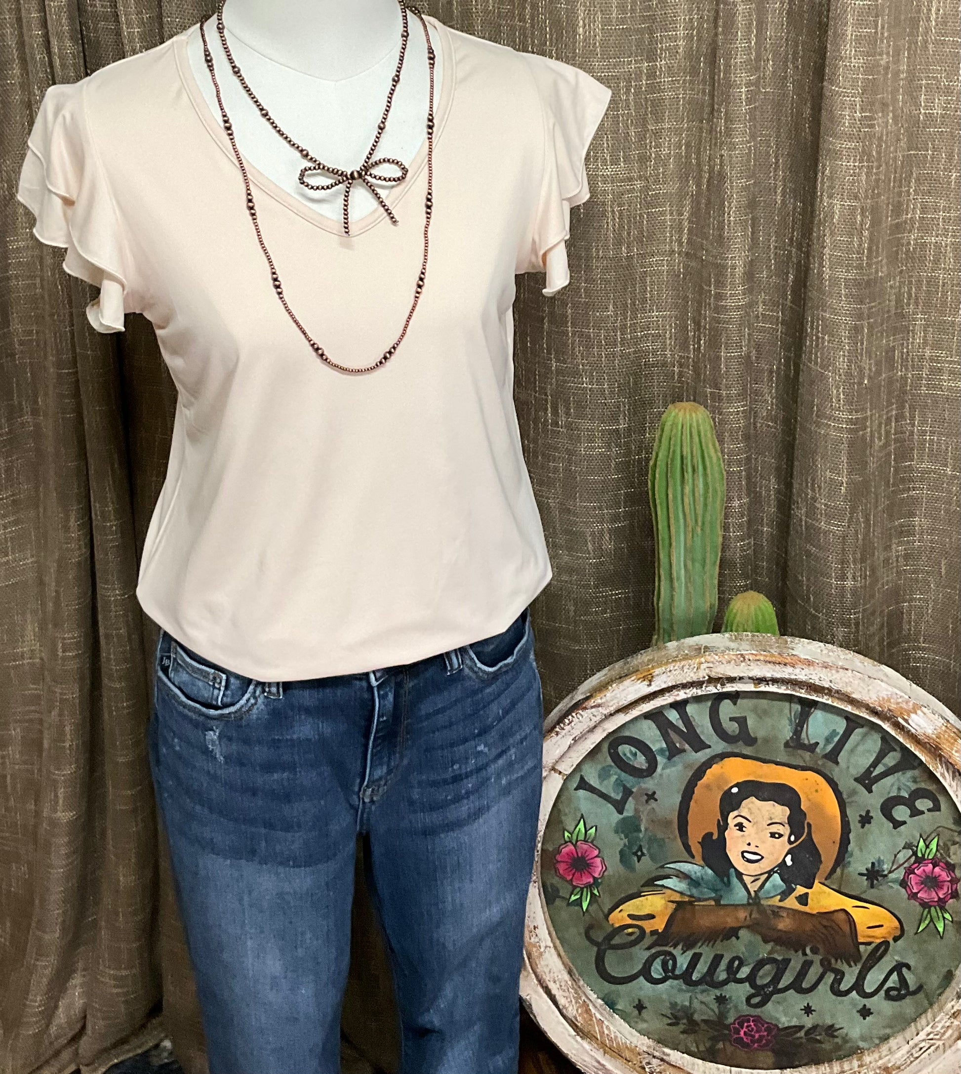 Image of the cream-colored Elaine Ruffle Top featuring a flattering V-neckline and delicate ruffle sleeves, crafted from luxuriously soft fabric for an effortlessly elegant look