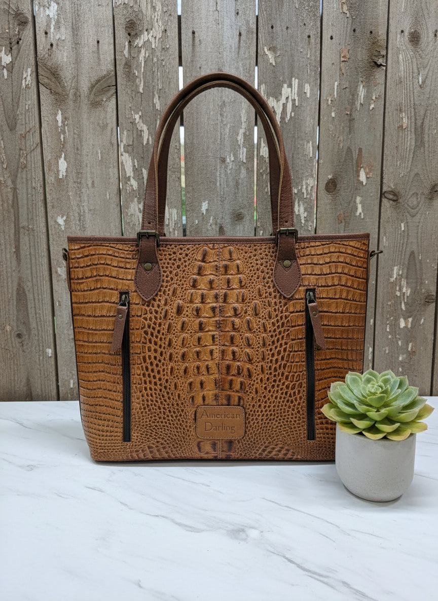 Brown crocodile-embossed leather tote with double straps, removable tassels, and detachable crossbody strap