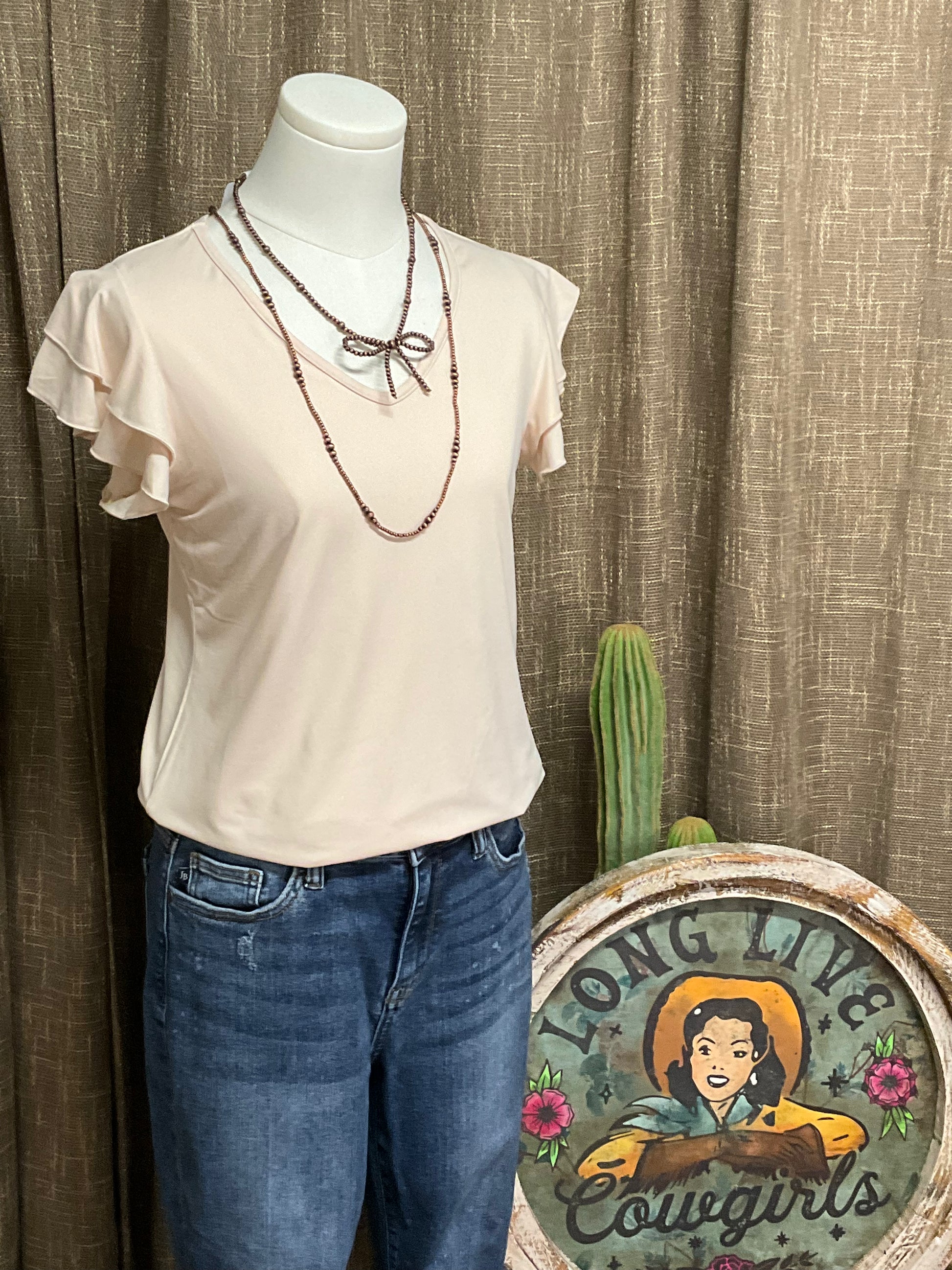 Image of the cream-colored Elaine Ruffle Top featuring a flattering V-neckline and delicate ruffle sleeves, crafted from luxuriously soft fabric for an effortlessly elegant look