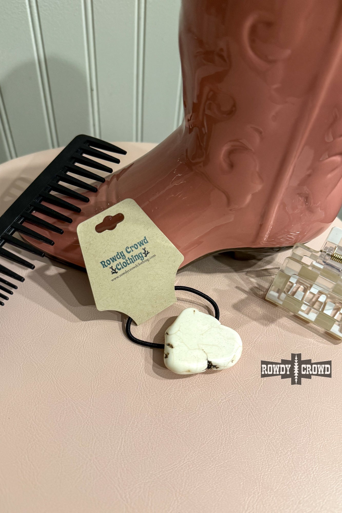 Never have a bad hair day again with the White Rock Ponytail Holder – a playful hair accessory featuring a uniquely sized and colored white slab rock, adding a touch of quirky style to your look.