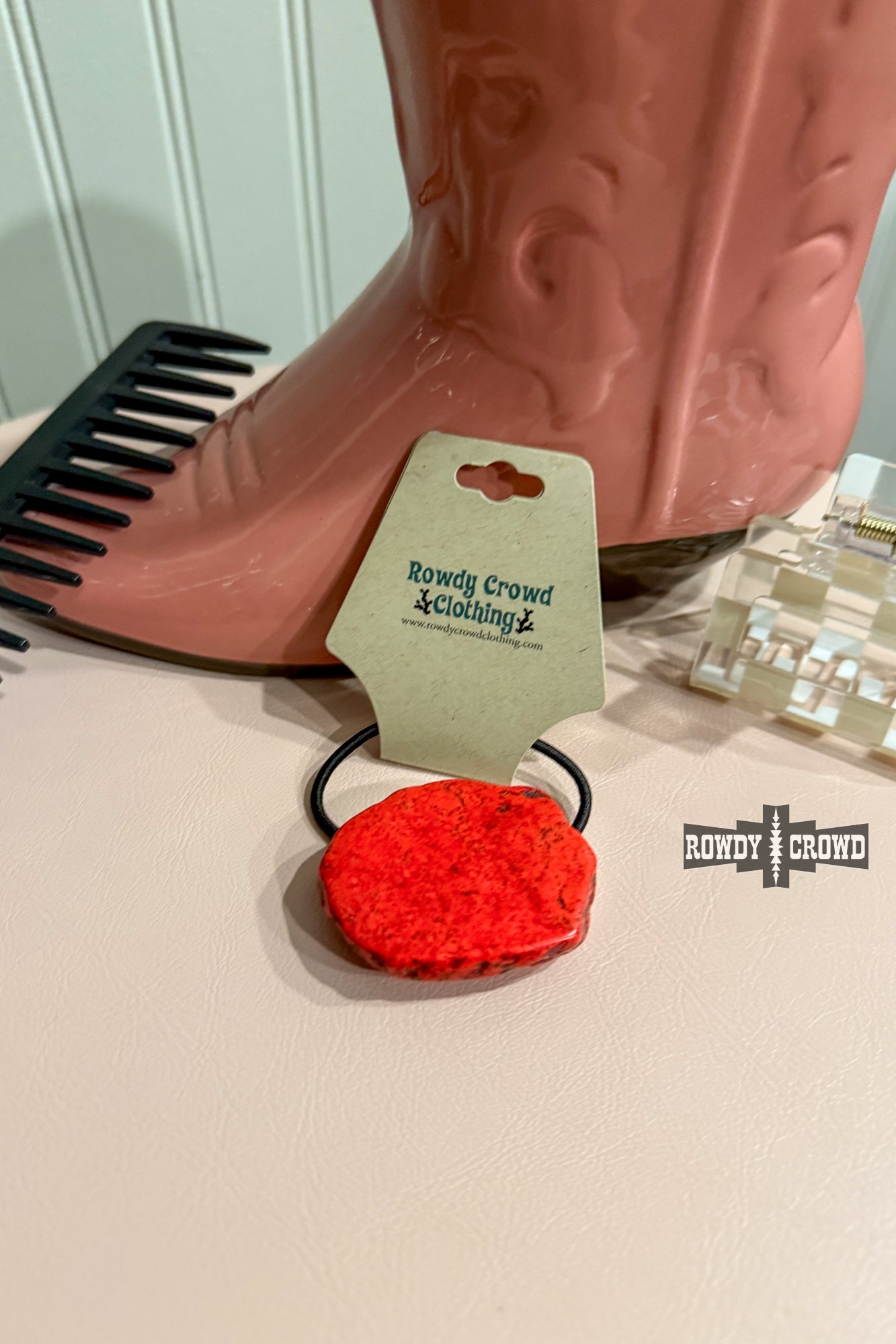 Never have a bad hair day again with the Red Rock Ponytail Holder – a playful hair accessory featuring a uniquely sized and colored red slab rock, adding a touch of quirky style to your look.