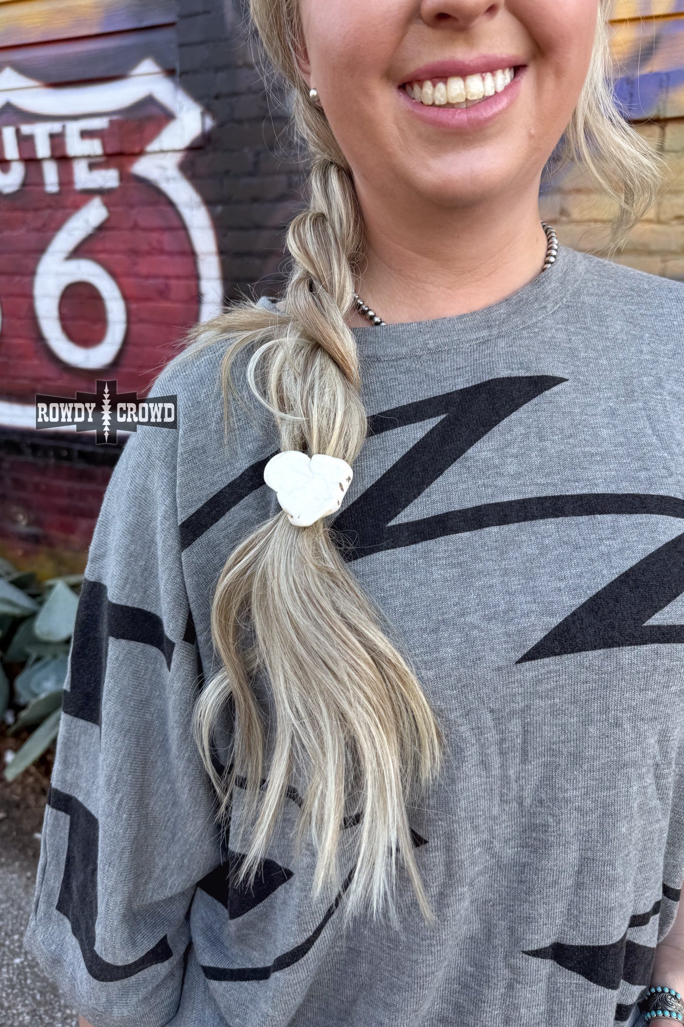 Never have a bad hair day again with the White Rock Ponytail Holder – a playful hair accessory featuring a uniquely sized and colored white slab rock, adding a touch of quirky style to your look.