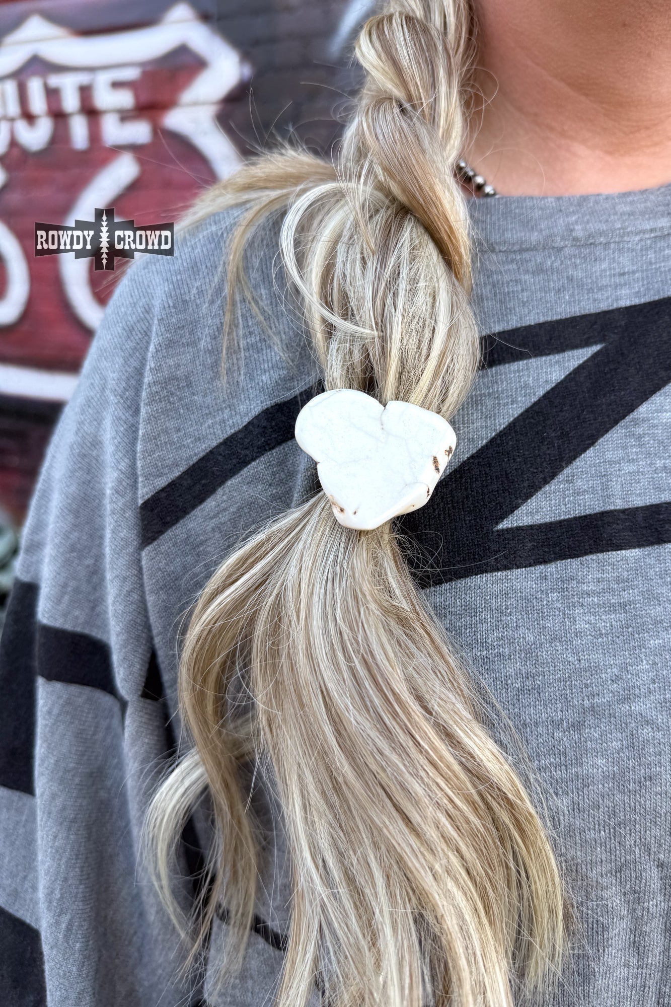 Never have a bad hair day again with the White Rock Ponytail Holder – a playful hair accessory featuring a uniquely sized and colored white slab rock, adding a touch of quirky style to your look.