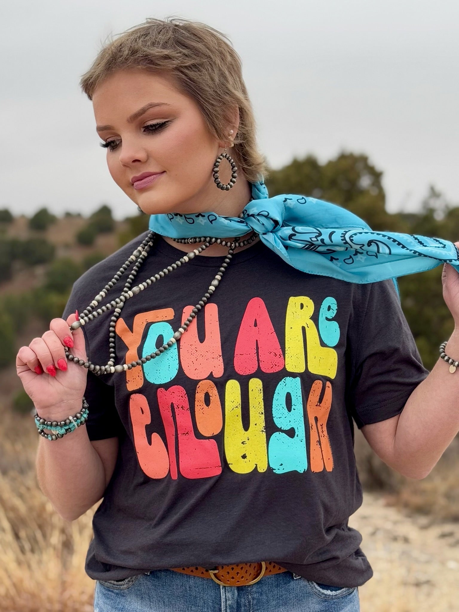 Dark grey Bella Canvas short sleeve tee with a colorful “You Are Enough” design in multicolored ink. The soft, breathable fabric and classic fit make it a versatile and empowering piece.