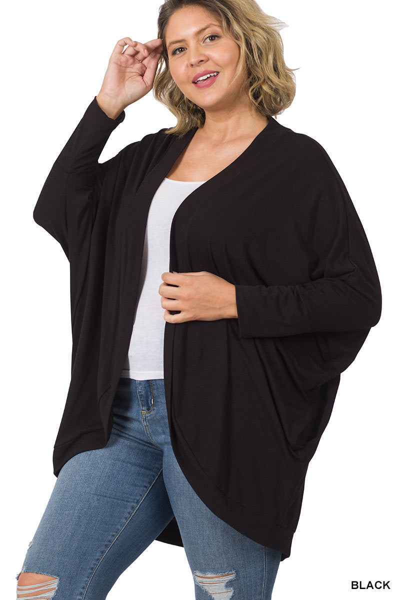 Model wearing a relaxed-fit cocoon wrap cardigan with a soft, draped silhouette. Lightweight, stretchy knit fabric shown layered over a tee and jeans for a cozy, casual outfit.