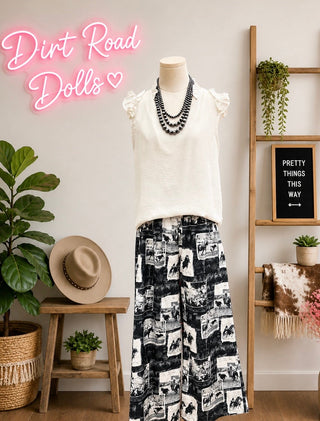 Black and white western print wide leg pants with smocked waistband and pockets styled with ivory ruffle sleeve top at Dirt Road Dolls Boutique