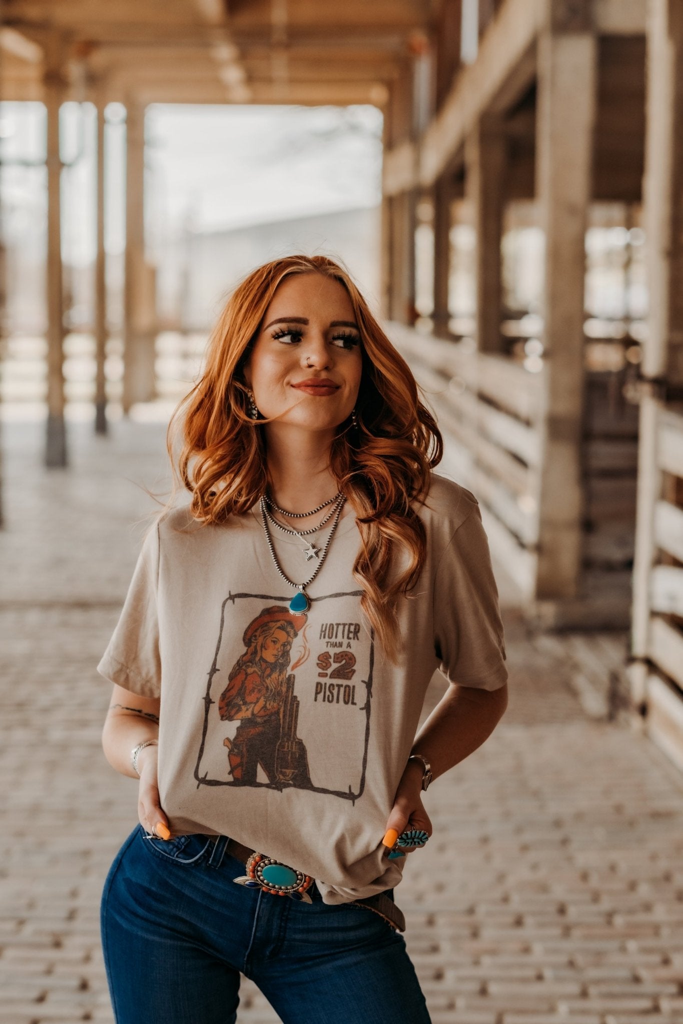 Tan tee with cowgirl graphic Hotter Than A $2 Pistol with barbwire border