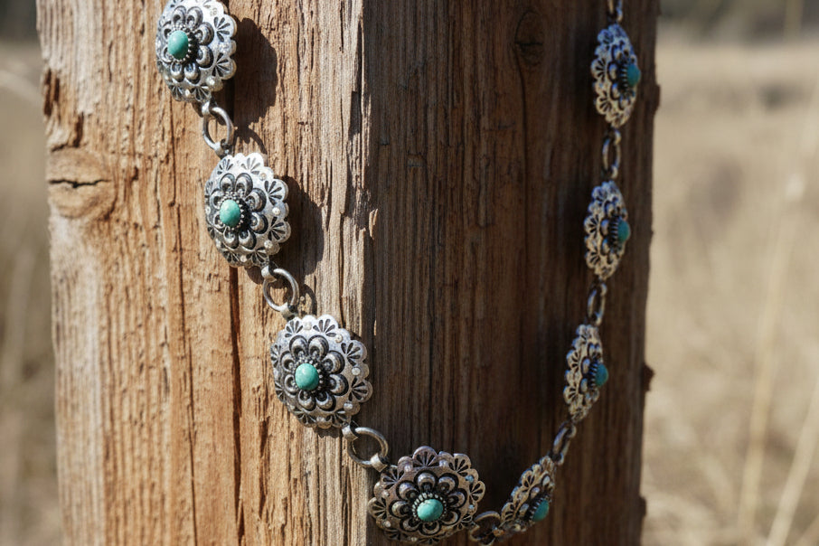 Western concho belt with scalloped round conchos, turquoise-colored center stones, and iridescent rhinestone details.