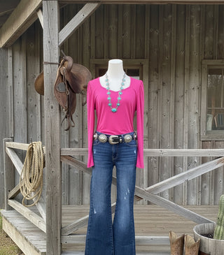 Risen Sawyer mid-rise flare jeans with light distressing and cut hem, women’s boutique denim.  Shown on mannequin with pink top