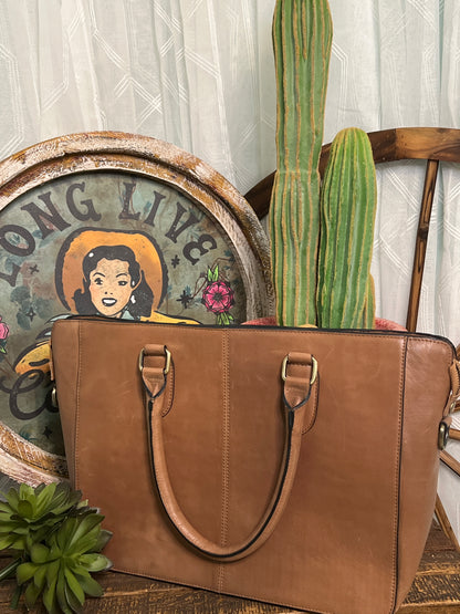 Brushy Creek Cowhide Tote:  handcrafted leather and cowhide tote purse, featuring a light brown and white cowhide front panel, a tassel on the front strap, a zippered closure, and an optional longer carrying strap. Approximate size: 14" x 10.5".