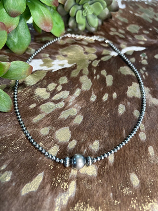 Sterling silver pearl necklace with large center pearl and saucer bead accents, adjustable extender chain.