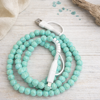 Light turquoise 4-in-1 phone charger with fast charging capability and multi-device connections in a clean boutique style