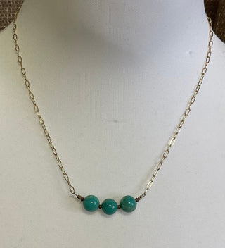 Close up of genuine turquoise beads with natural matrix on bronze necklace