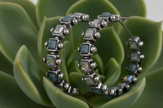Silver-tone hoop earrings with alternating turquoise-style stones and iridescent rhinestones, approximately 1.5 inches in size.