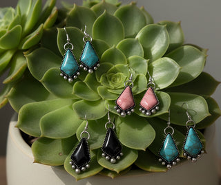 Silver-tone drop earrings with geometric colored stones in turquoise, pink, and black, accented with small silver bead details.