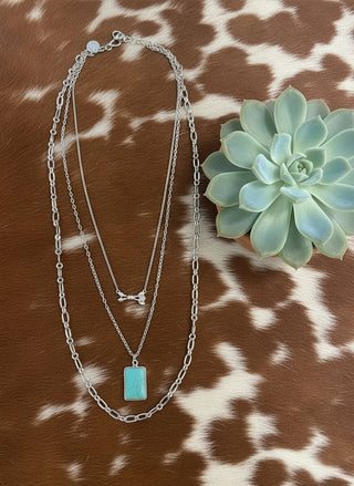 triple strand necklace with paperclip chains arrow pendant and turquoise detail