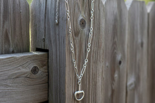 Silver-tone single chain necklace with a snaffle bit–shaped pendant.
