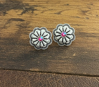 Silver tone floral stud earrings with bright pink rhinestone centers.