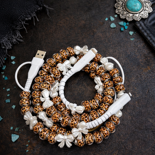 Leopard print phone charger with bow accents featuring 4-in-1 connections, fast charging, and bold boutique style